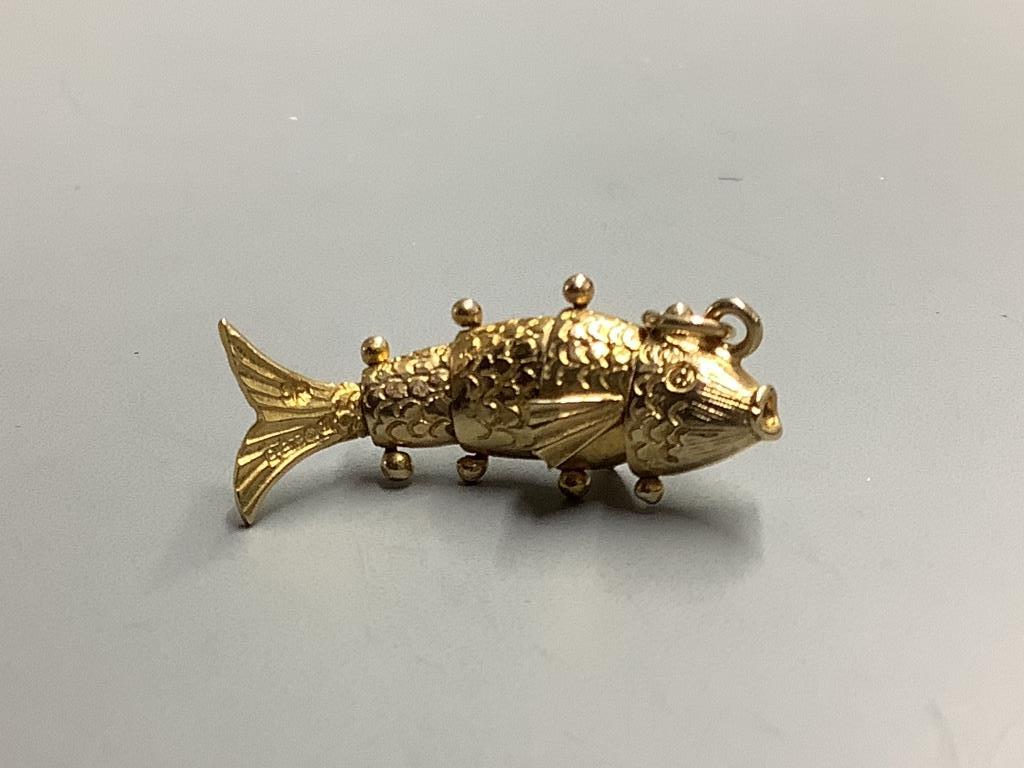 A modern 9ct gold articulated fish charm and a 9ct gold wedding band, gross 7.8 grams.